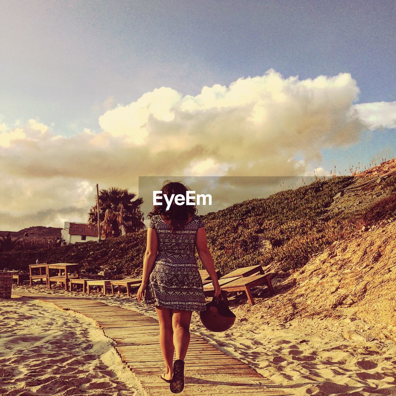 FULL LENGTH REAR VIEW OF A MAN WALKING AGAINST CLOUDS