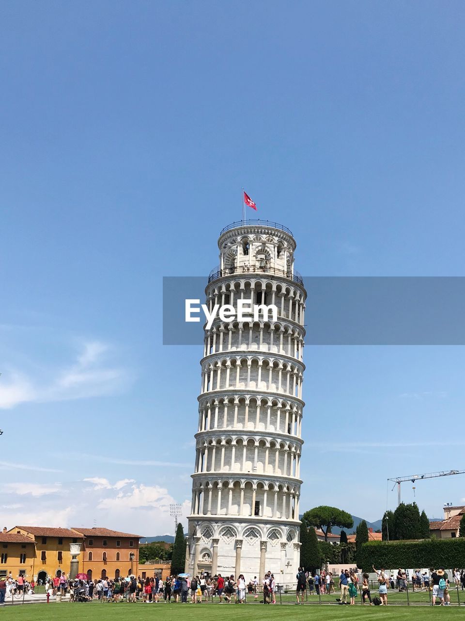 Group of people in front of leaning tower against sky