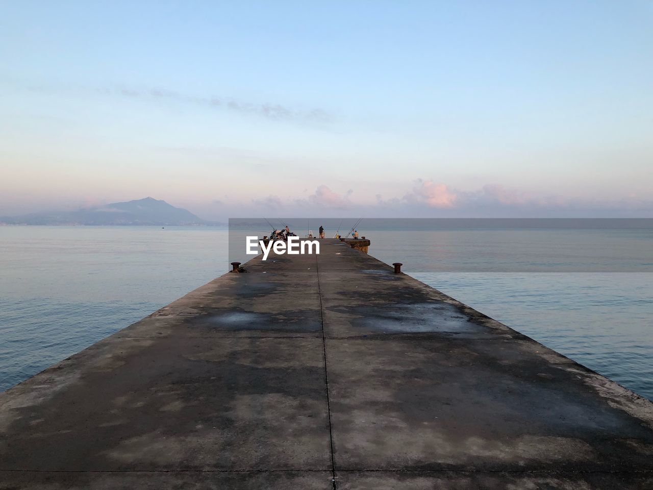 Pier over sea against sky during sunset