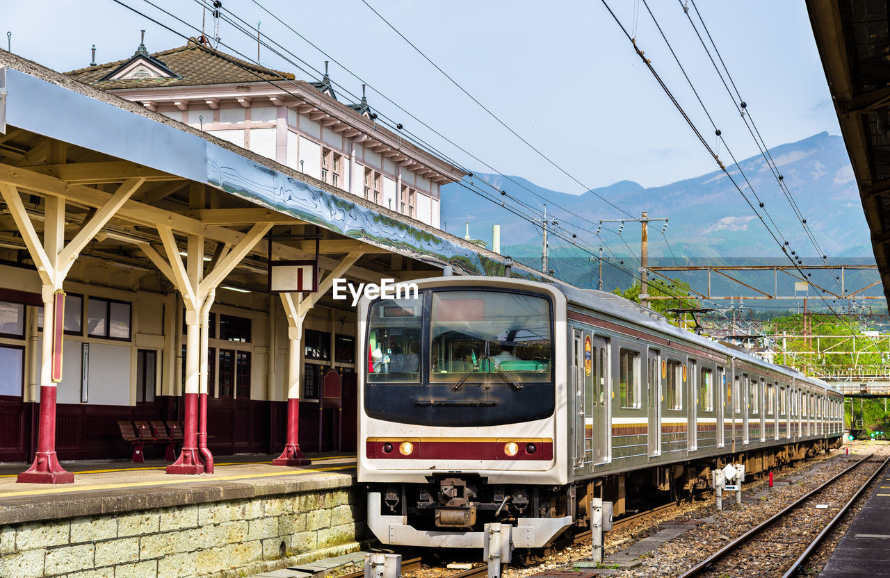 TRAIN AT RAILROAD STATION PLATFORM AGAINST SKY