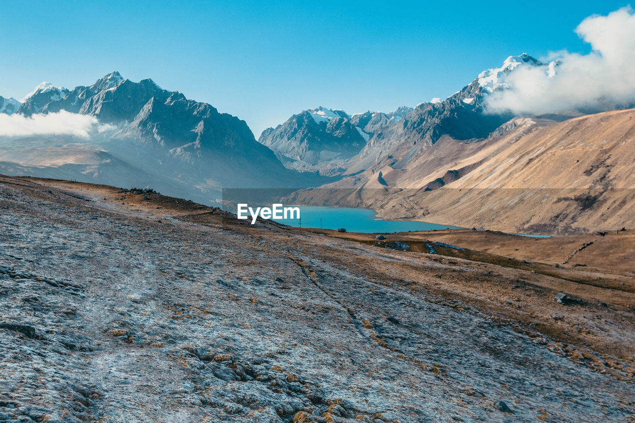 Scenic view of lake amidst mountains against blue sky