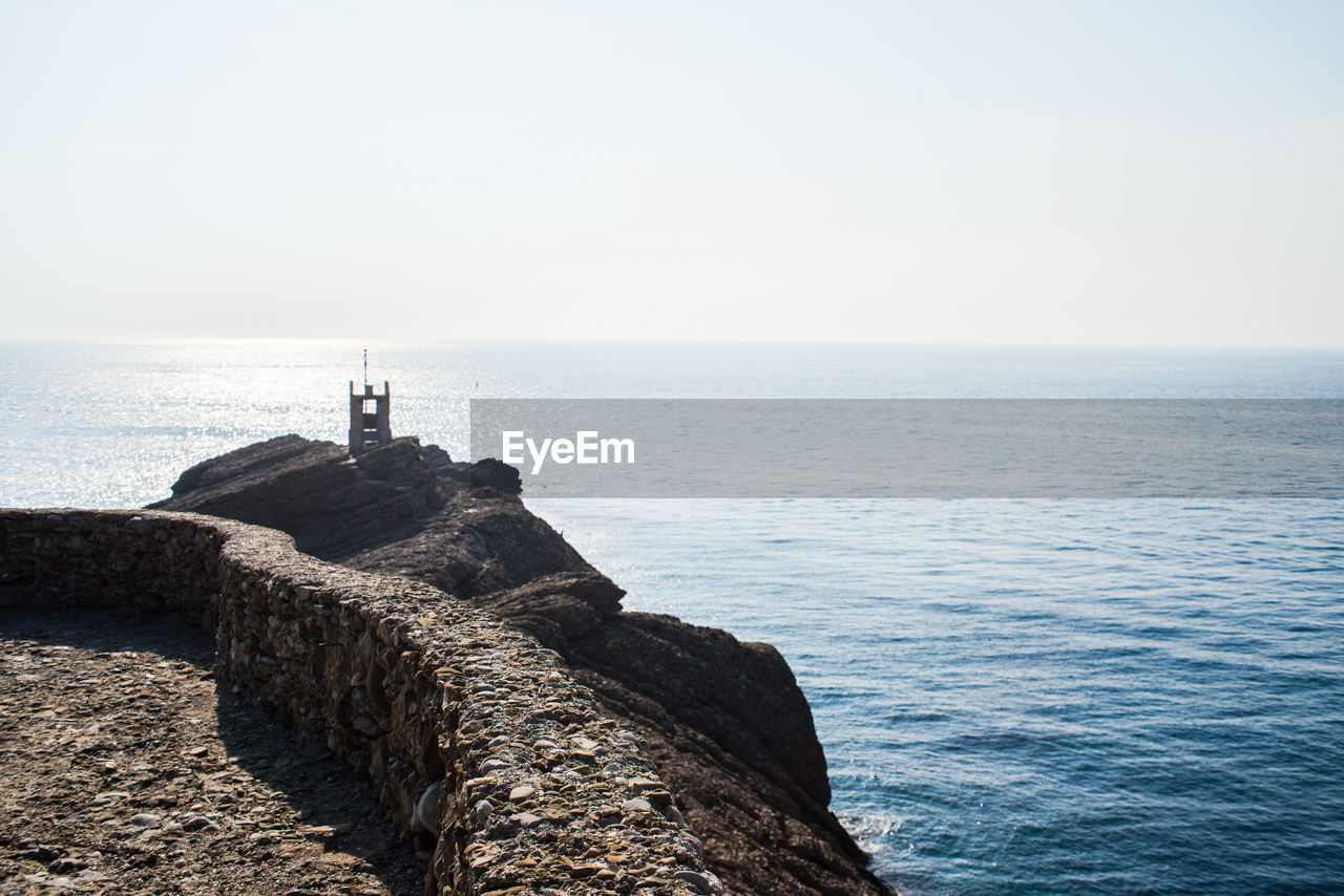 LIGHTHOUSE ON SEA AGAINST CLEAR SKY