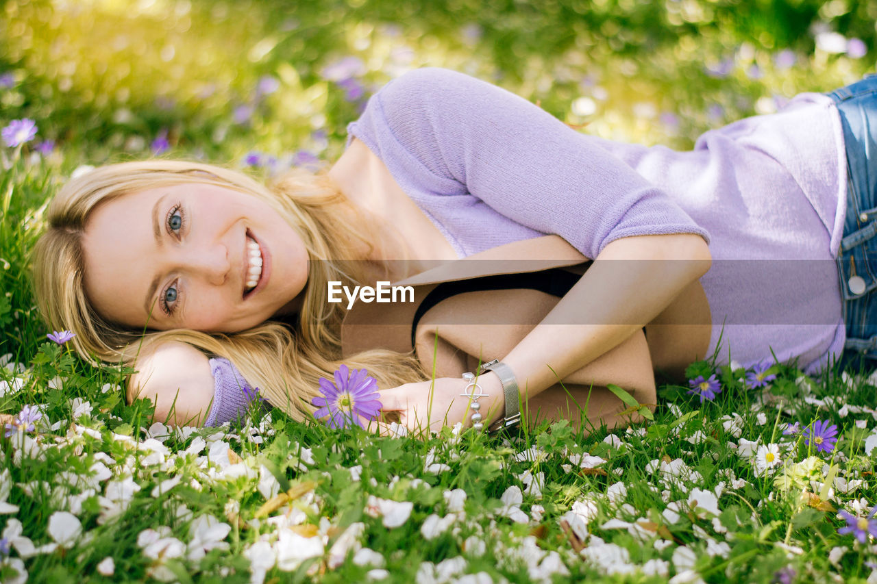 Portrait of young woman lying on grass