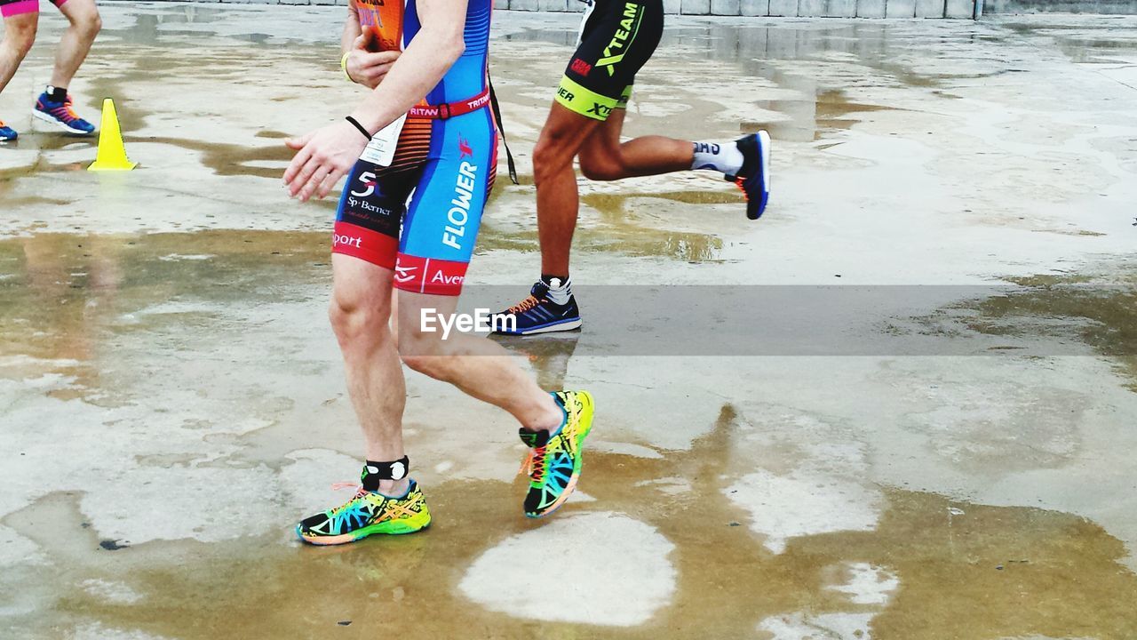 Low section of runners exercising on street during rainy season