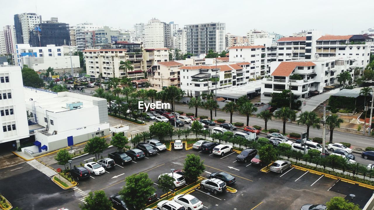 High angle view of cars parked at parking lot by traffic in city