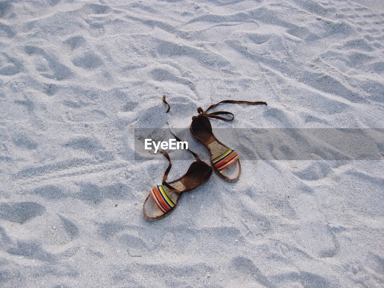 High angle view of footwear on sand at beach