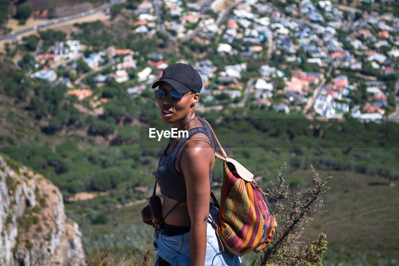 Portrait of woman in sunglasses standing on hill