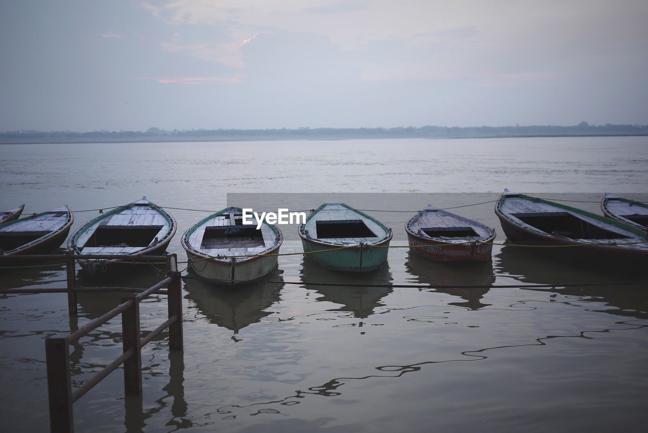 Boats moored in sea against sky