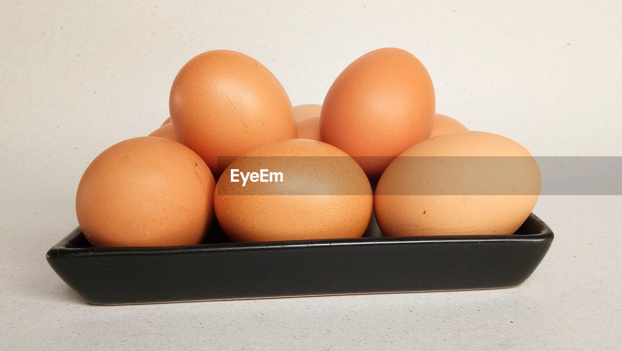 Close-up of eggs in plate against white background