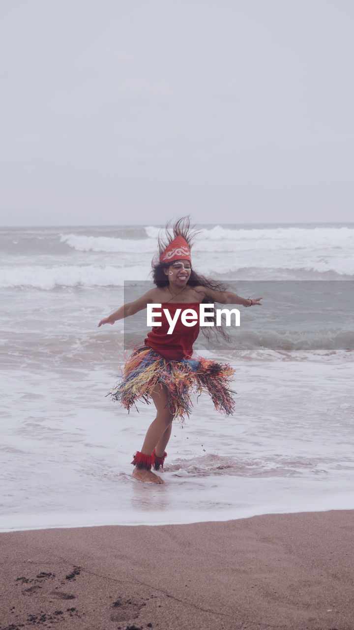 Rear view of woman standing at beach