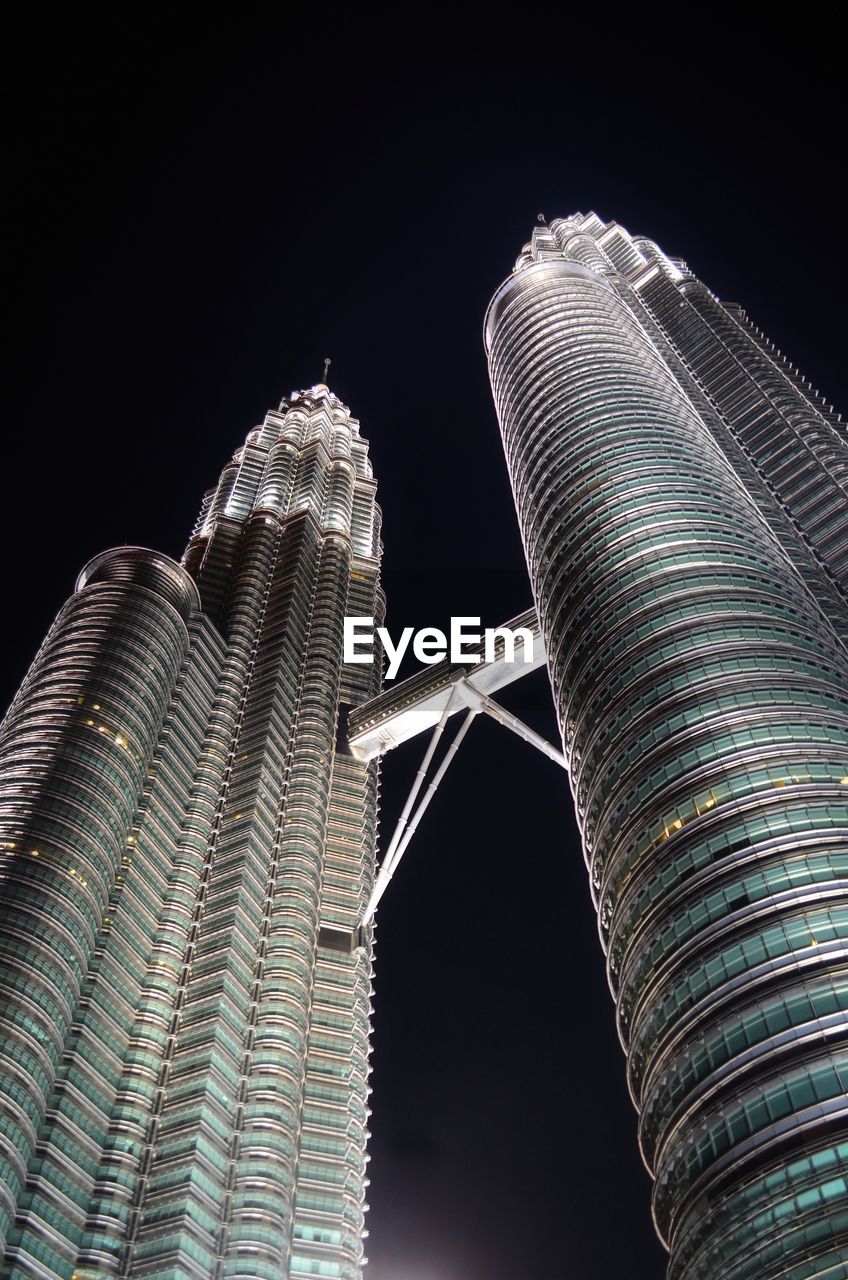 Low angle view of illuminated buildings klcc against sky at night