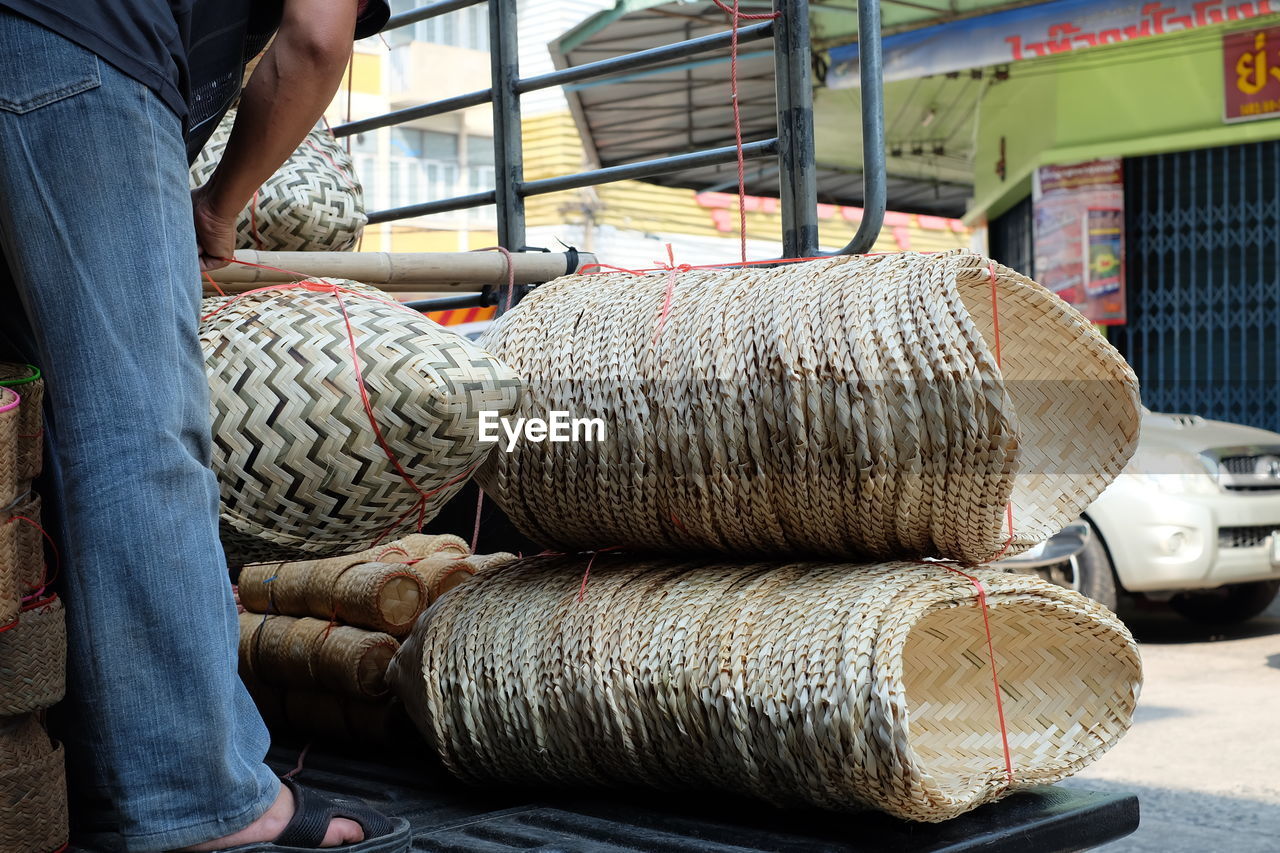 Low section of man loading wicker baskets on vehicle