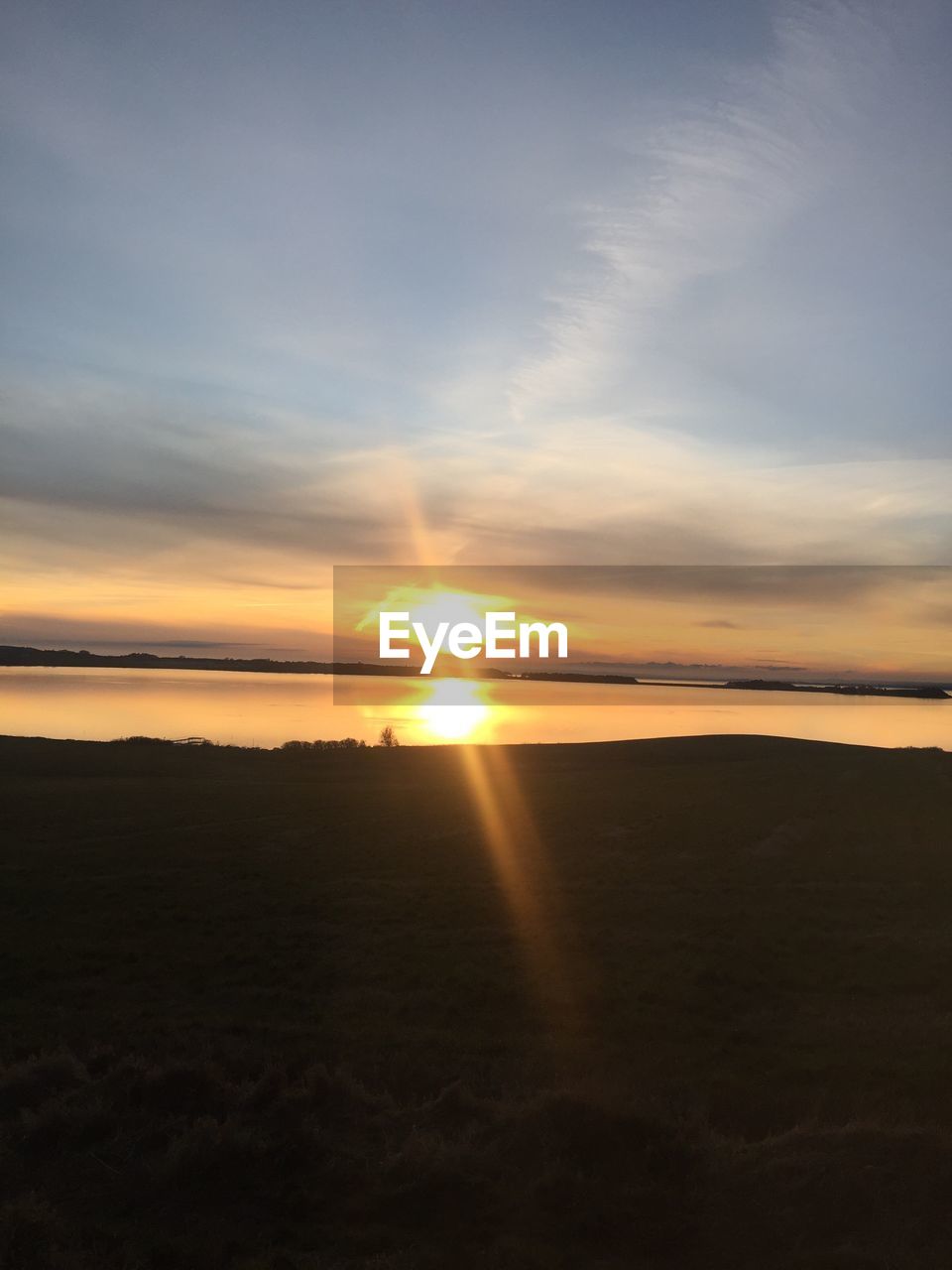 SCENIC VIEW OF BEACH AGAINST SKY AT SUNSET