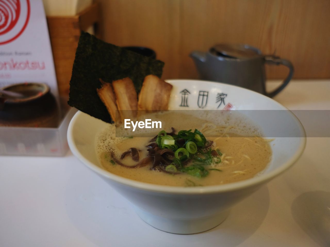 CLOSE-UP OF SOUP IN BOWL WITH TABLE