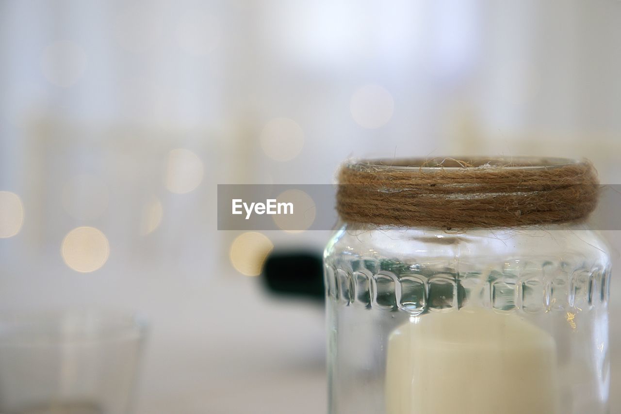 CLOSE-UP OF WINE GLASS WITH BOTTLES