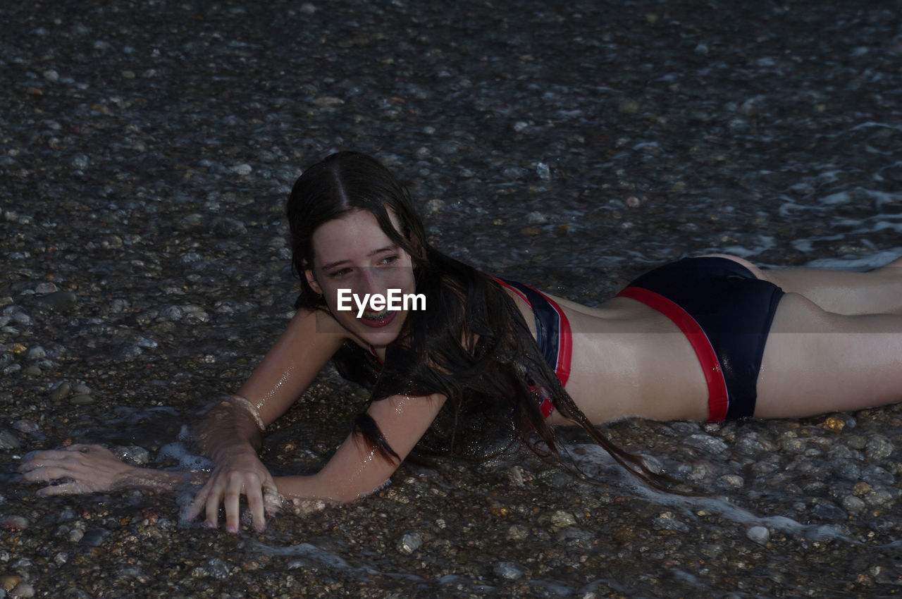 Smiling young woman lying at beach