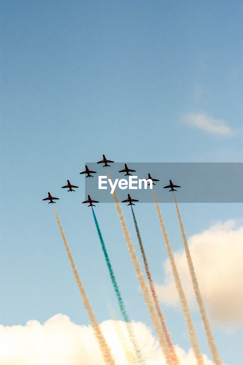 Low angle view of airplanes flying against sky