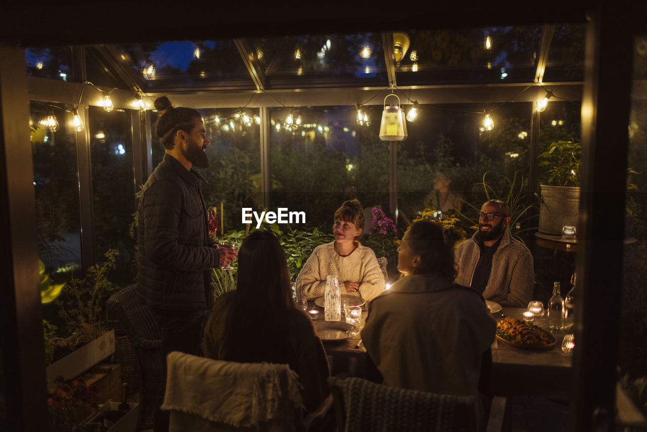 Friends having meal in greenhouse