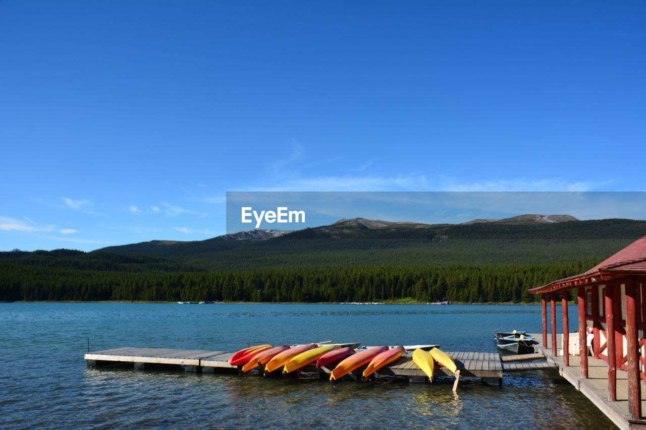 Multi colored canoes on pier over lake