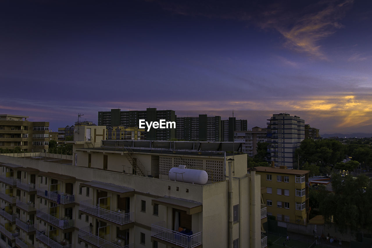 Buildings in city against cloudy sky