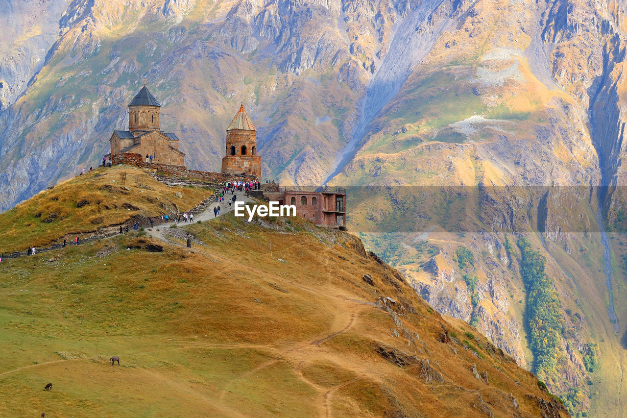 Gergeti trinity church or tsminda sameba on the hilltop with mount kazbek , georgia
