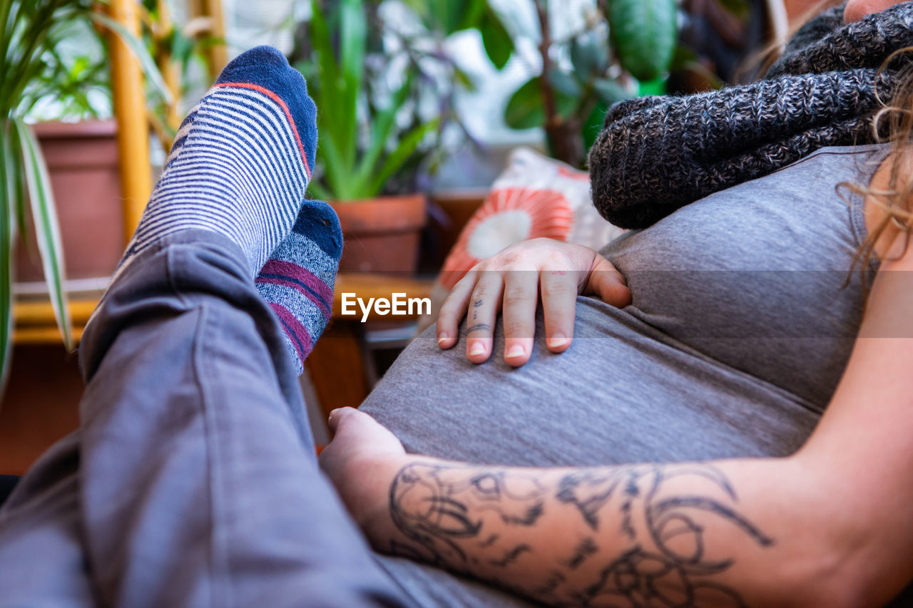 Midsection of woman with hands sitting on floor