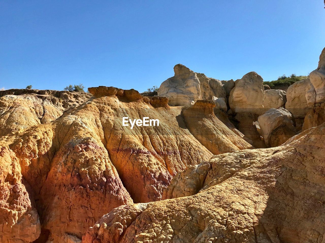 Rock formations against clear blue sky