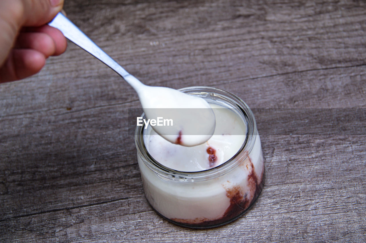 HIGH ANGLE VIEW OF PERSON HAND HOLDING ICE CREAM