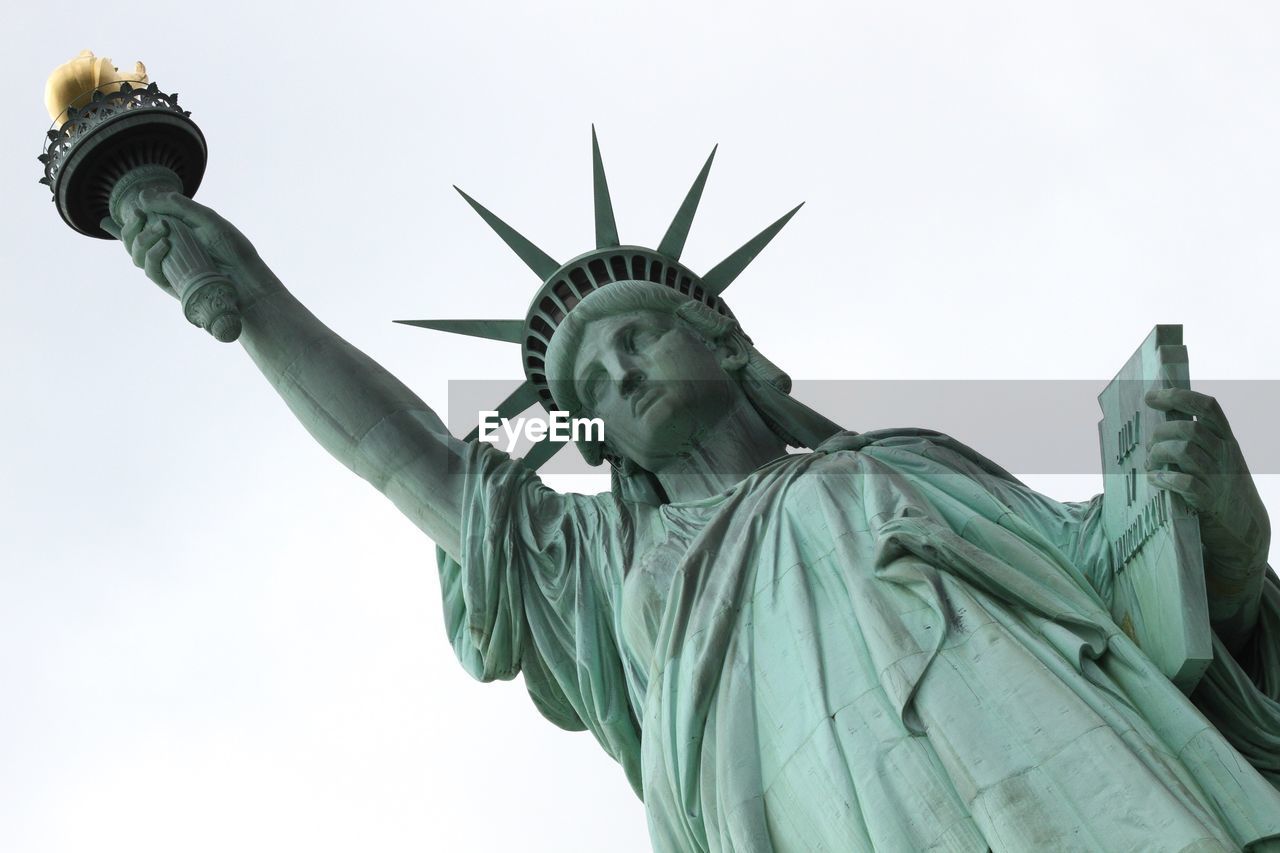 Low angle view of historic statue of liberty against sky