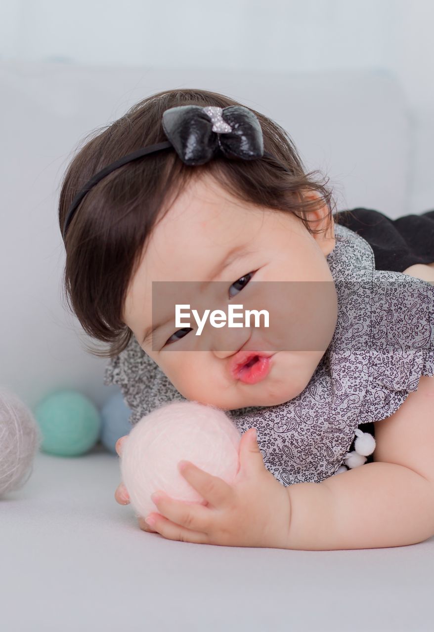 Portrait of cute baby girl playing with ball at home