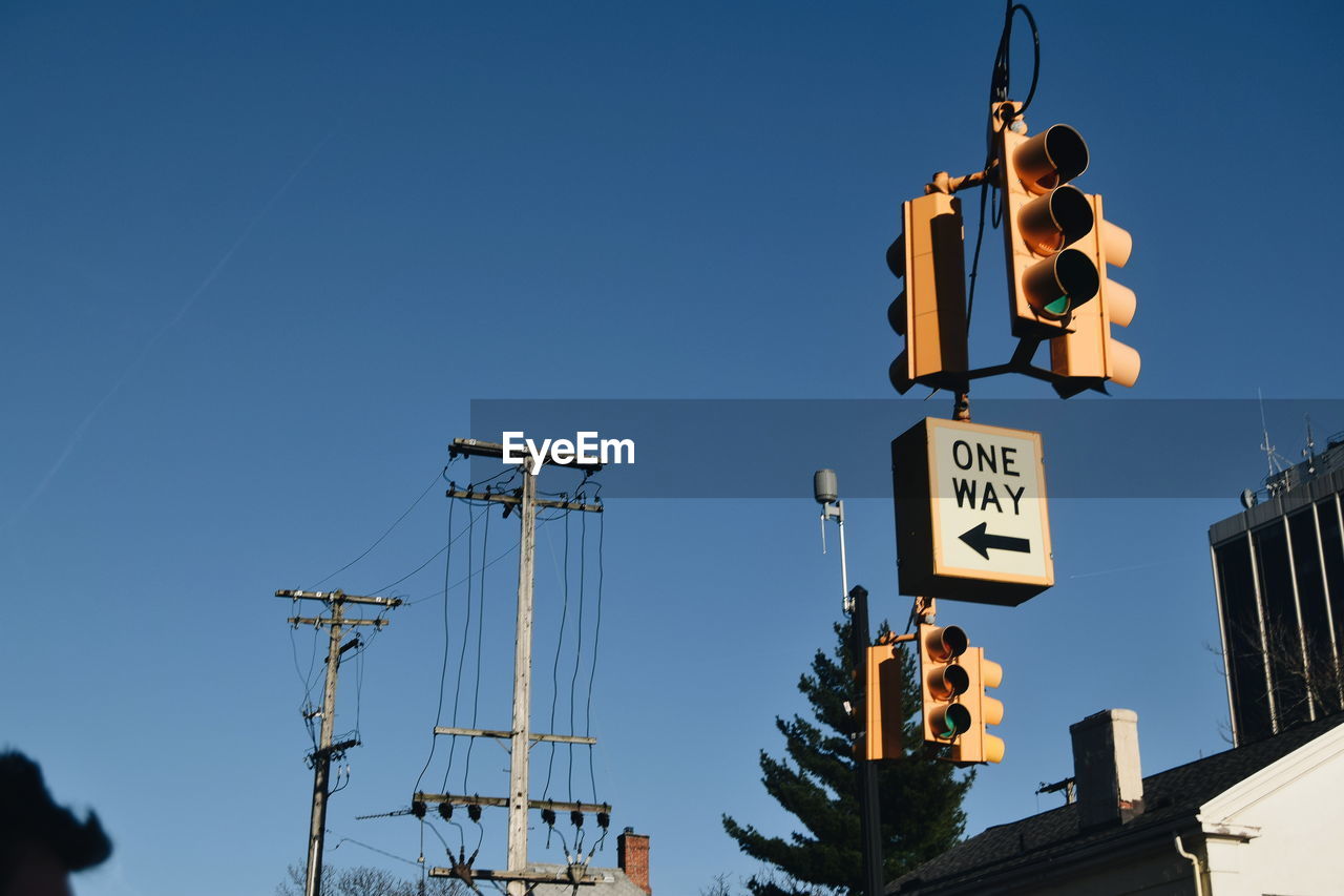 Low angle view of signboard against clear blue sky