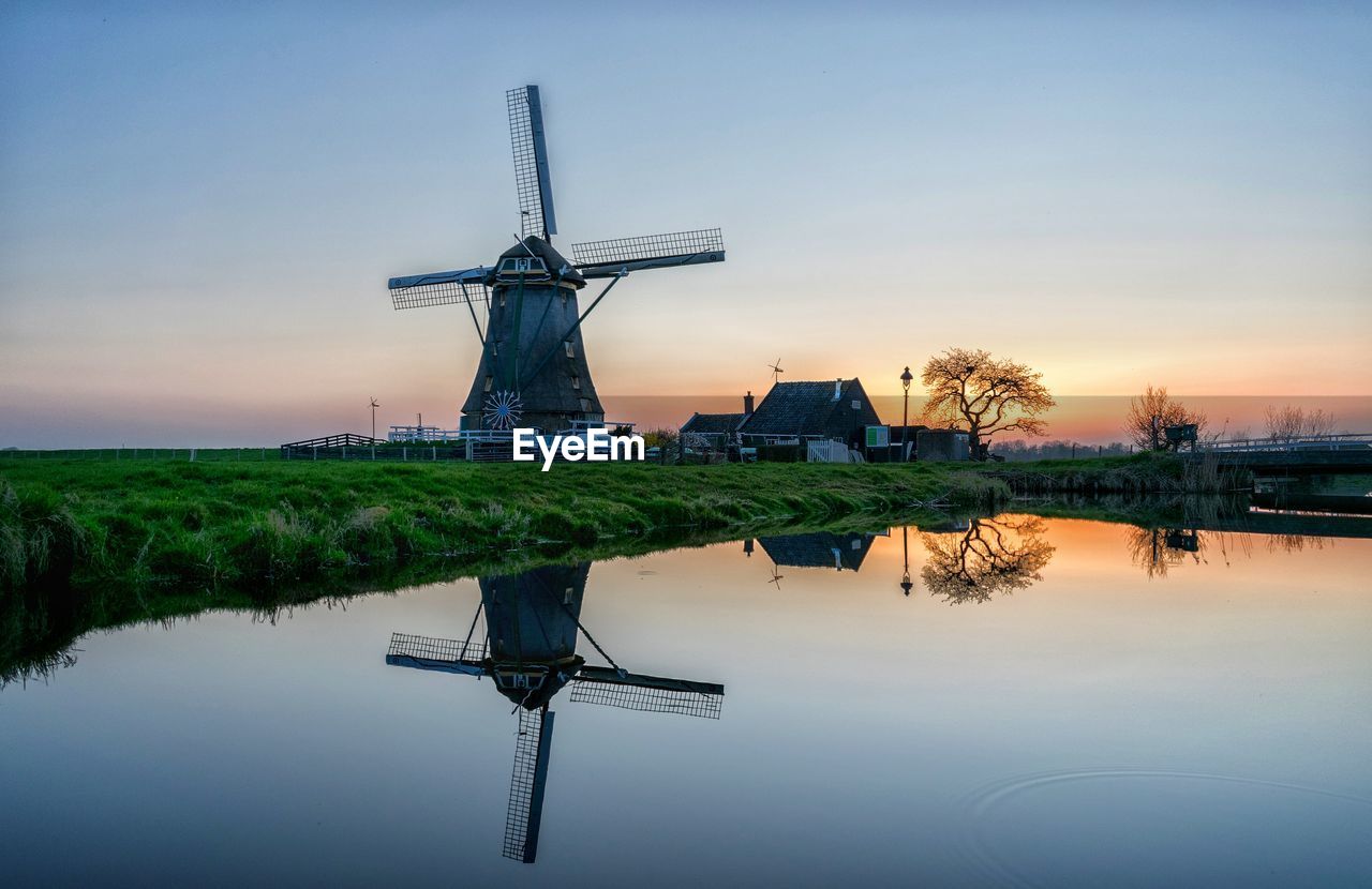 Scenic view of windmill against sky during sunset