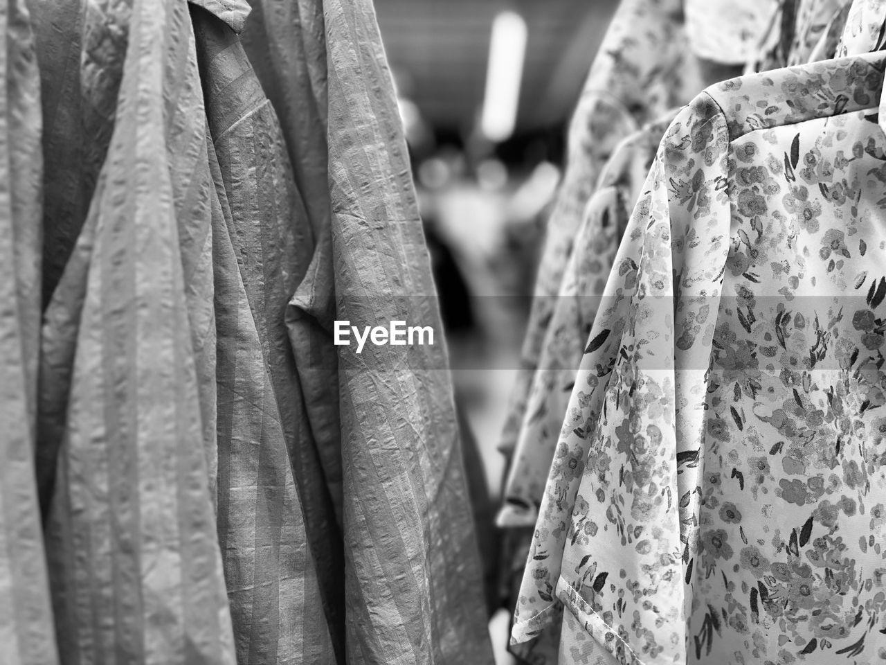 retail, clothing, black and white, hanging, store, textile, spring, dress, monochrome photography, no people, shopping, monochrome, for sale, black, close-up, fashion, focus on foreground, coathanger, white, business finance and industry, outerwear, pattern, business, market, clothing store, variation, day, large group of objects, sale, retail display, consumerism