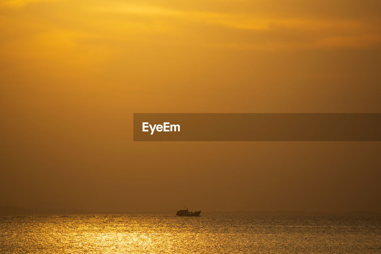 SCENIC VIEW OF SEA AGAINST ORANGE SKY DURING SUNSET