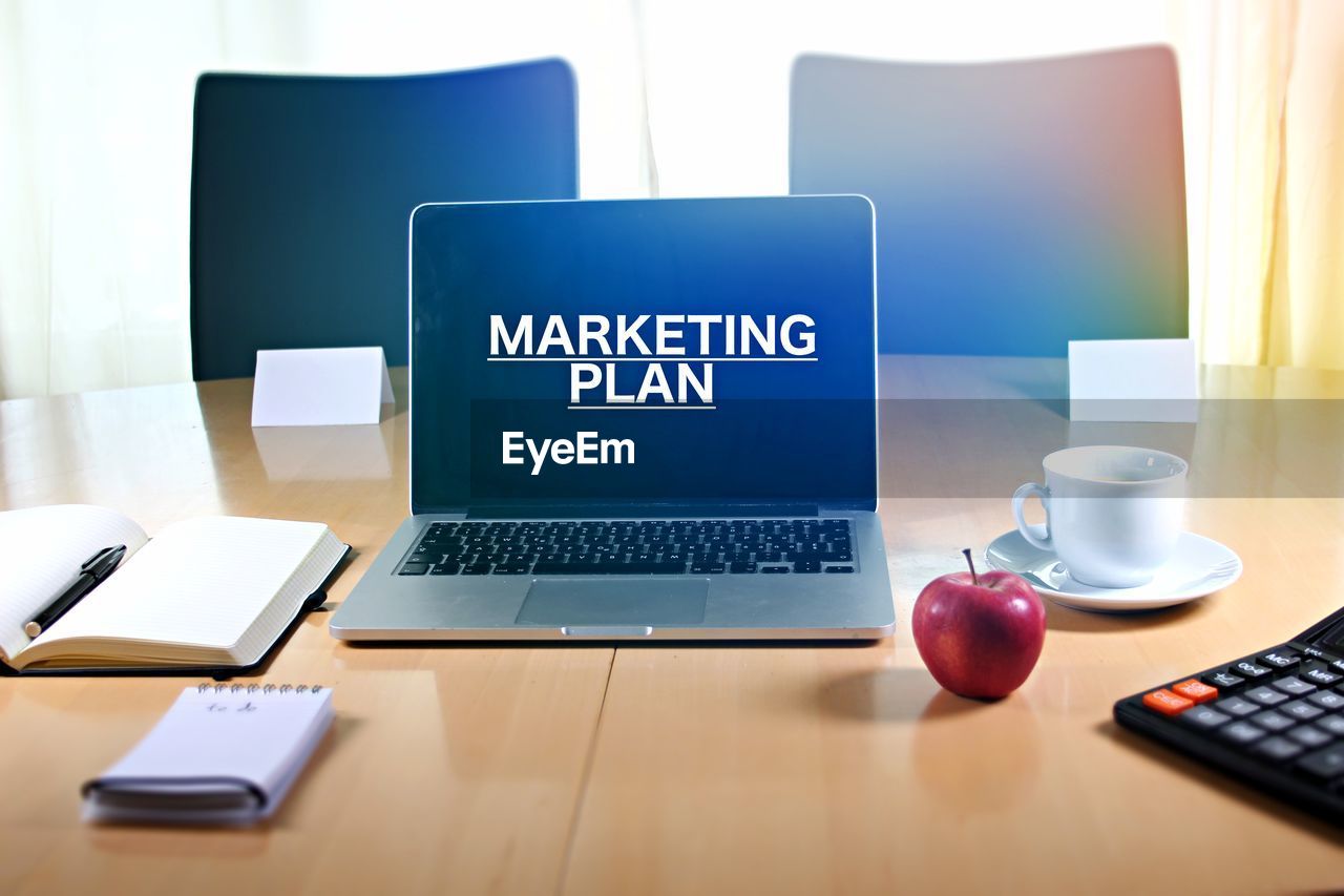 Marketing plan text on laptop at desk in office