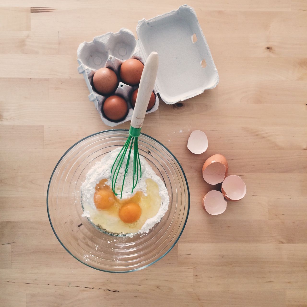 High angle view of egg and flour in bowl on table