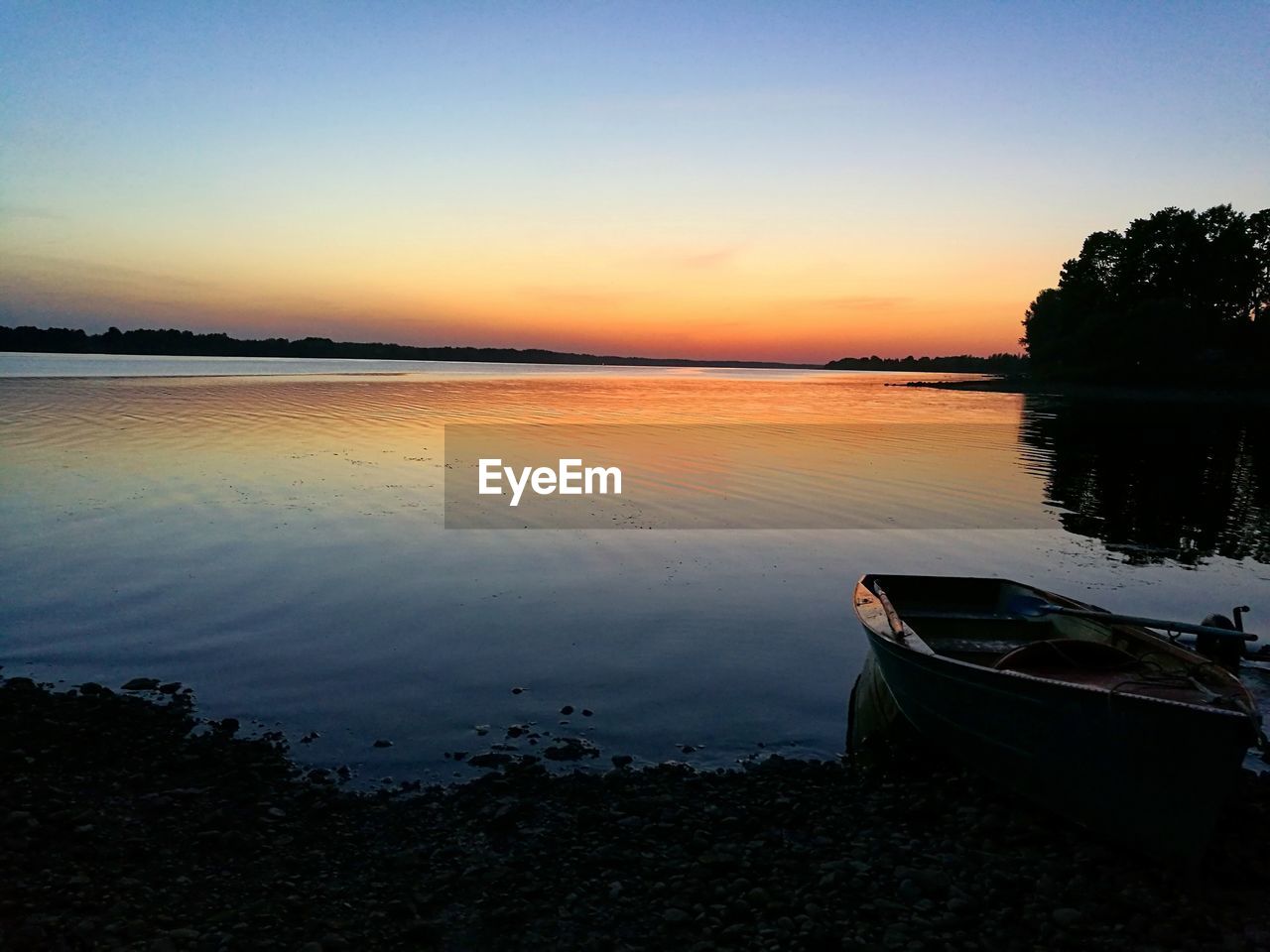 Scenic view of lake against clear sky during sunset