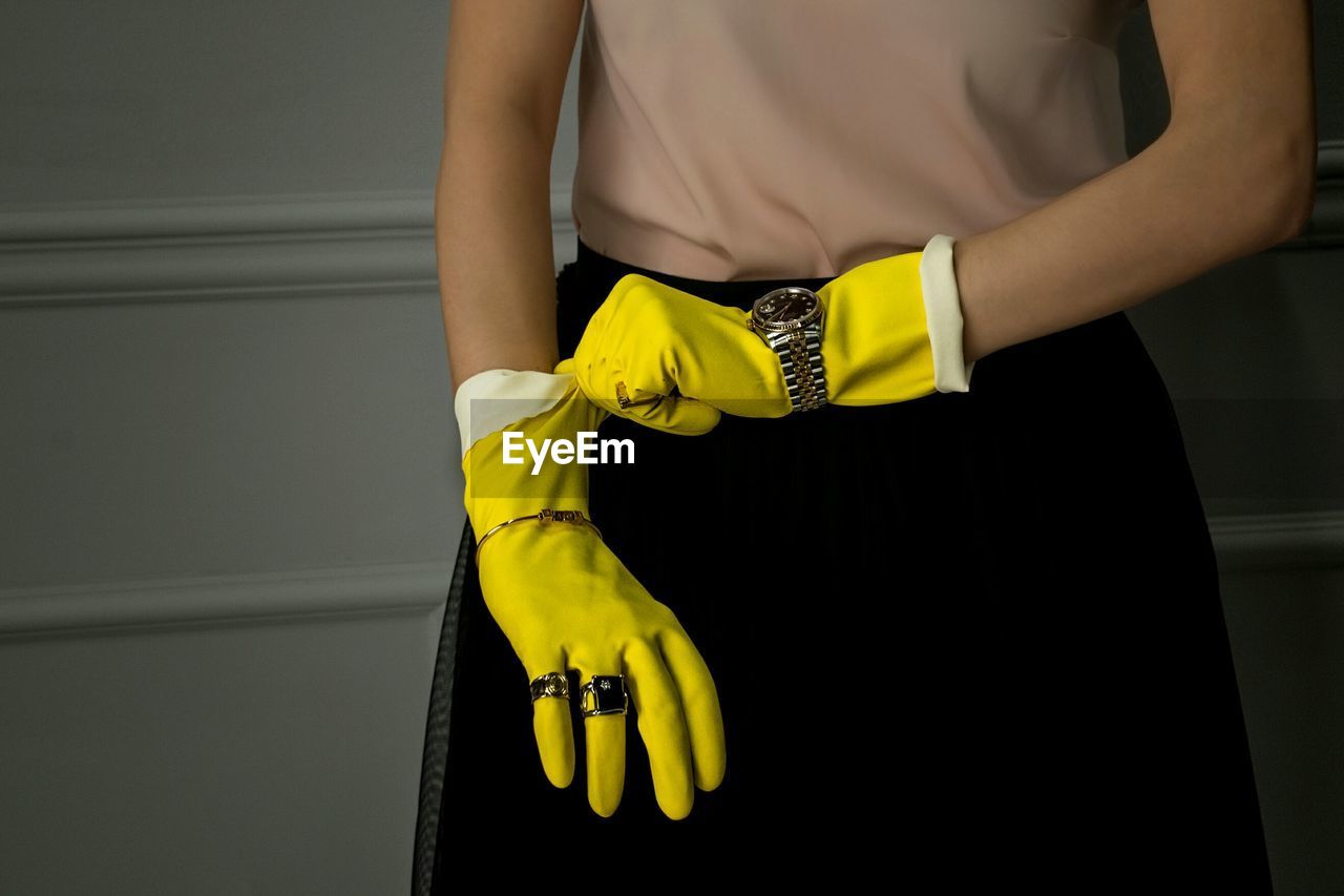 Midsection of woman wearing yellow gloves