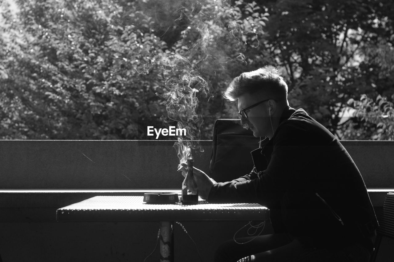 Side view of man smoking outdoors