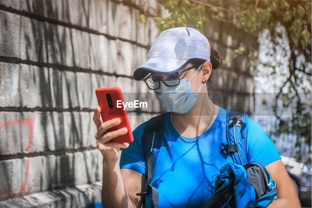 Close-up of woman wearing mask using mobile phone