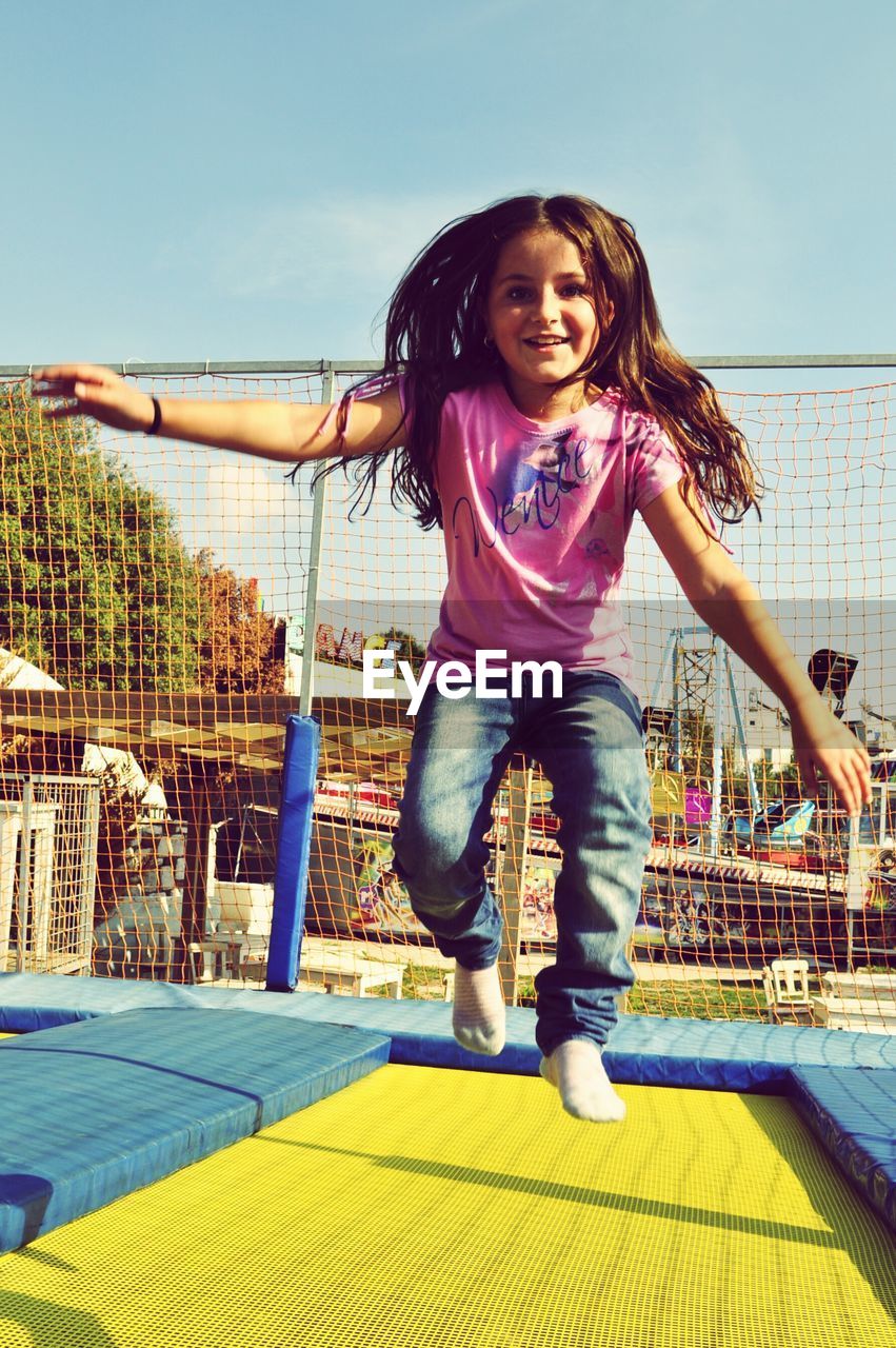 Portrait of happy girl jumping on trampoline