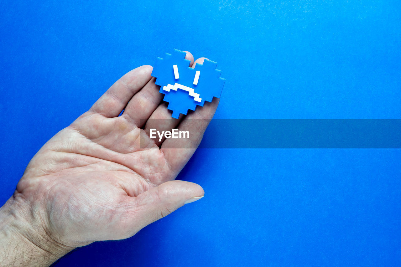 hand, blue, finger, blue background, colored background, one person, studio shot, indoors, holding, close-up, arm, men, adult