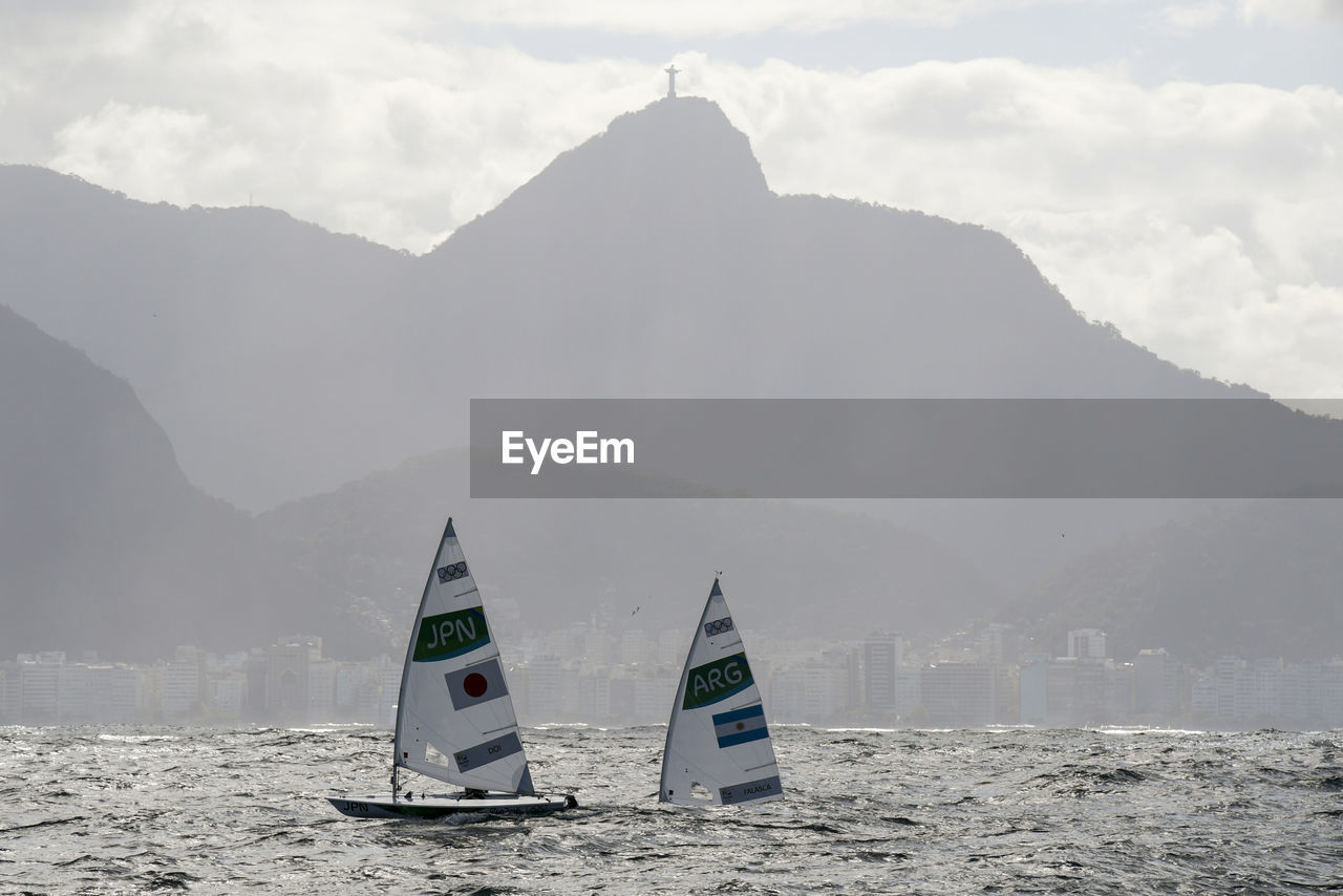 Scenic view of sea and mountains against sky