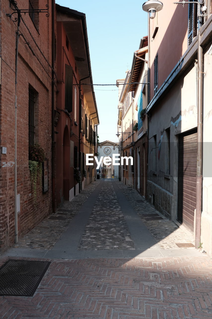 Empty alley amidst buildings in city