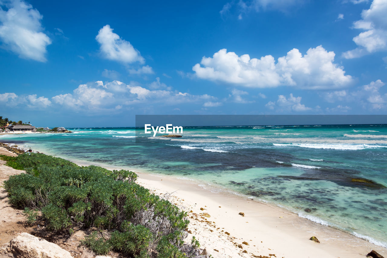 Scenic view of beach against cloudy blue sky