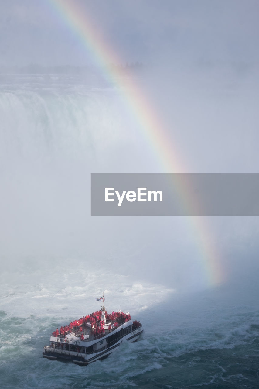 Scenic view of rainbow over sea against sky