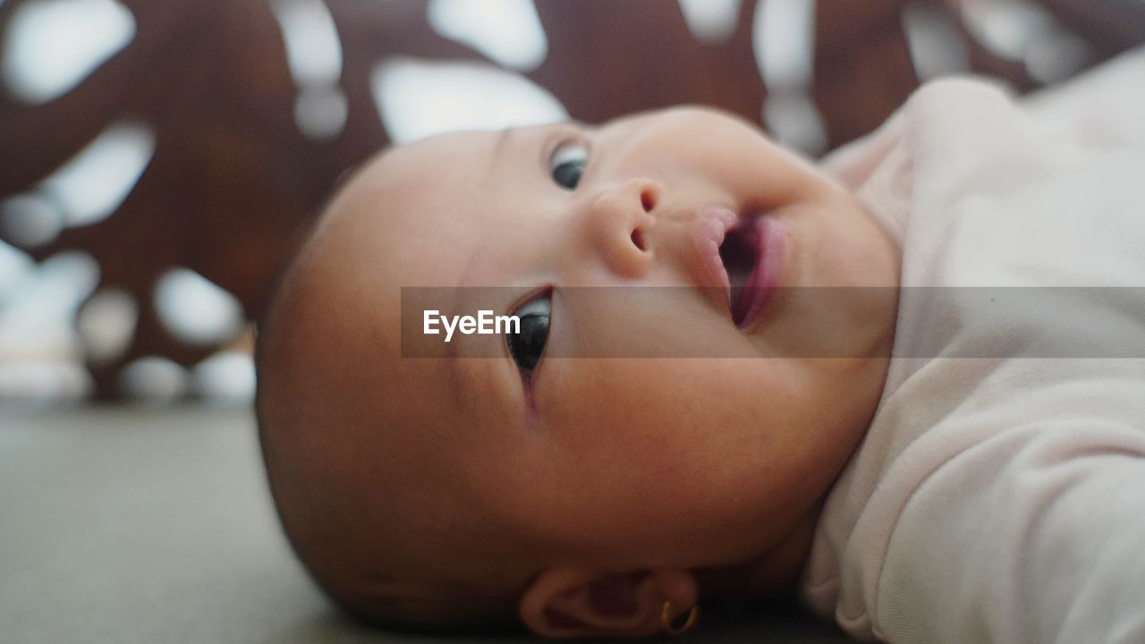 Close-up of cute baby boy lying on bed