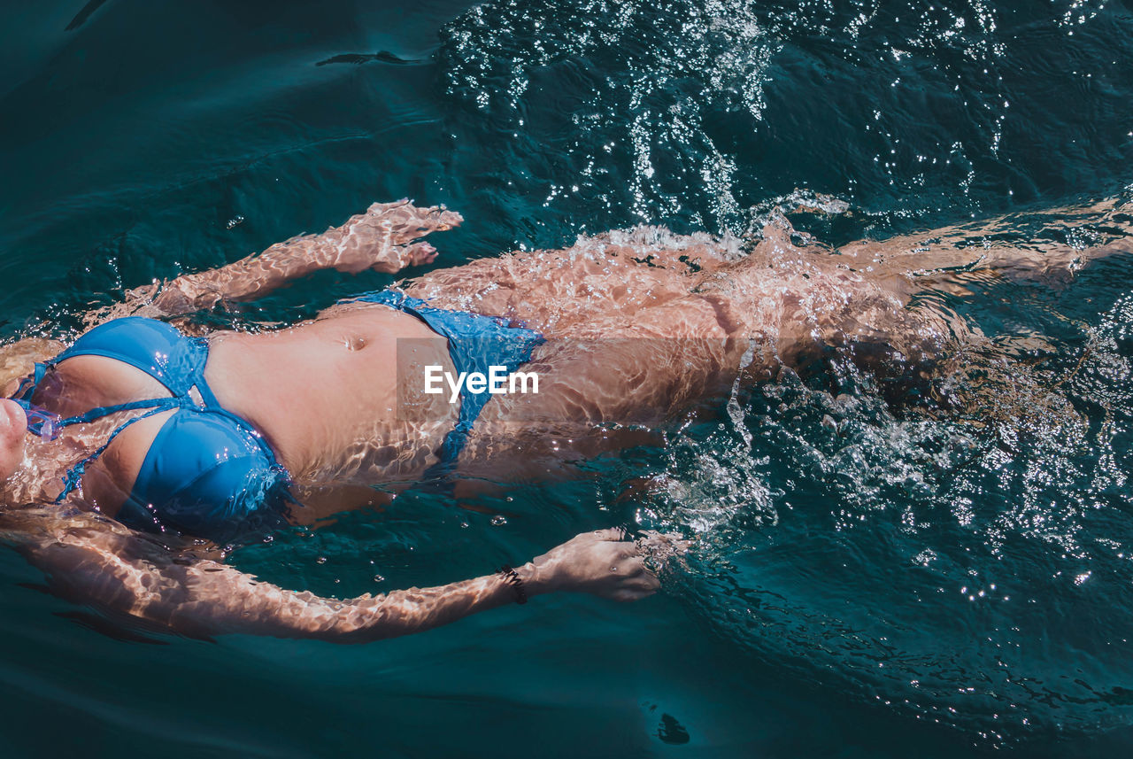 High angle view of bikini woman swimming in sea