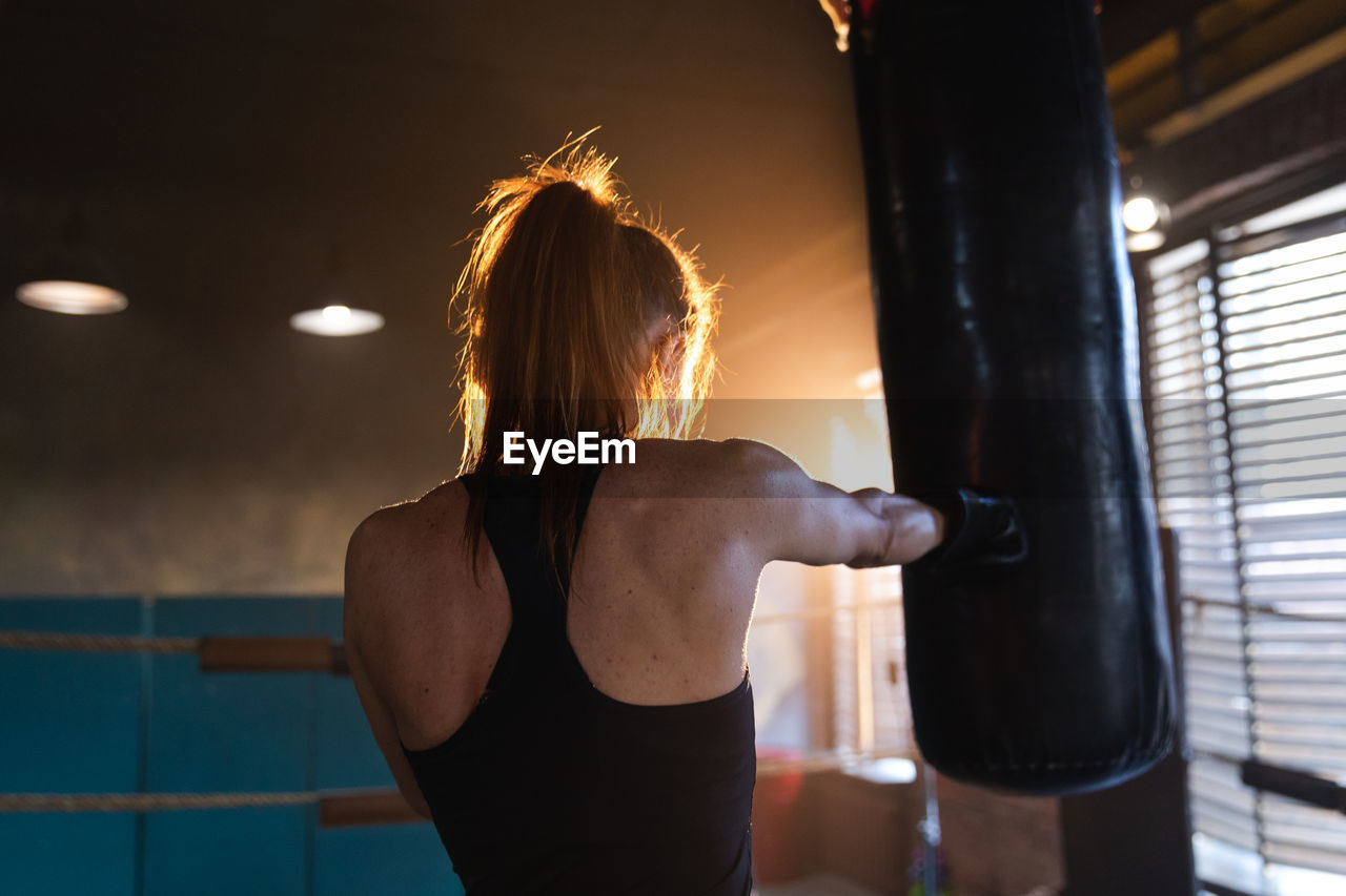 rear view of young woman standing in gym