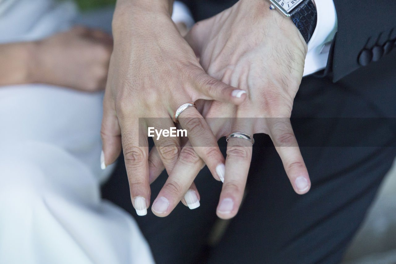 Cropped image of bride and groom showing wedding rings